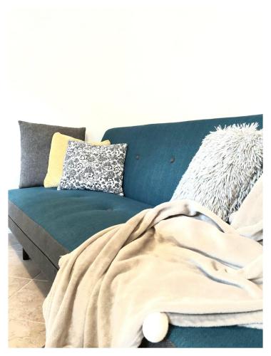 a blue couch with pillows and a blanket on it at House Old Town Trogir in Trogir