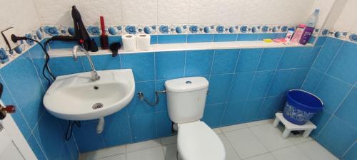 a blue tiled bathroom with a toilet and a sink at Casa Lotfi 1 in Chefchaouene