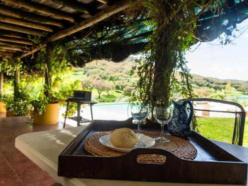 a table with a plate of food and wine glasses at Farmhouse in Montemor near Forest and Lake in Montemor-o-Novo