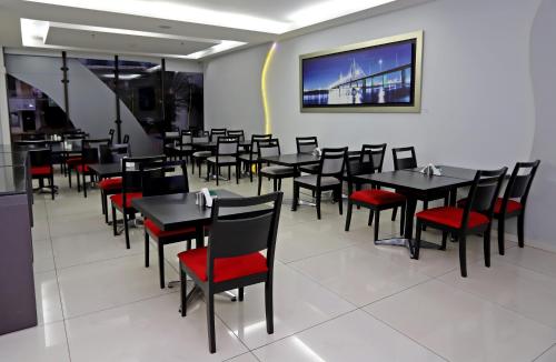 une salle à manger avec des tables noires et des chaises rouges dans l'établissement Bella Vista Hotel - Encarnación, à Encarnación