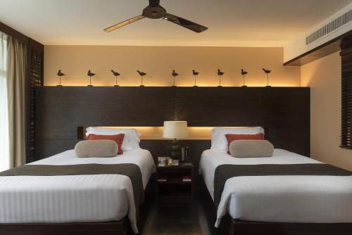 two twin beds in a hotel room at Centara Grand Mirage Beach Resort Pattaya - SHA Extra Plus in North Pattaya