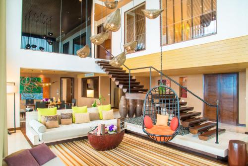 a living room filled with furniture and lots of windows at Centara Grand Mirage Beach Resort Pattaya - SHA Extra Plus in Pattaya North