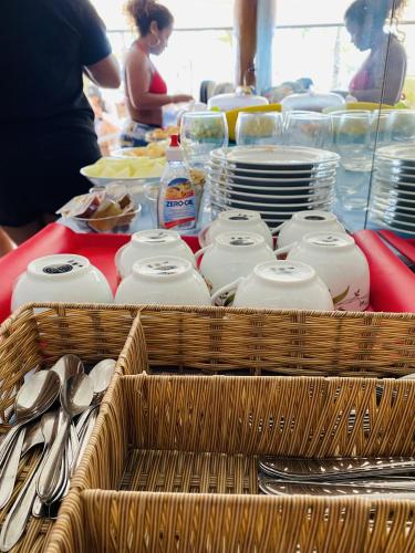 Pousada Sweet Home في بوزيوس: طاولة عليها سلال من الأطباق والأواني