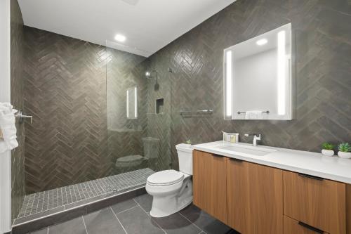 a bathroom with a toilet and a shower and a sink at Global Luxury Suites at Tribeca in Washington