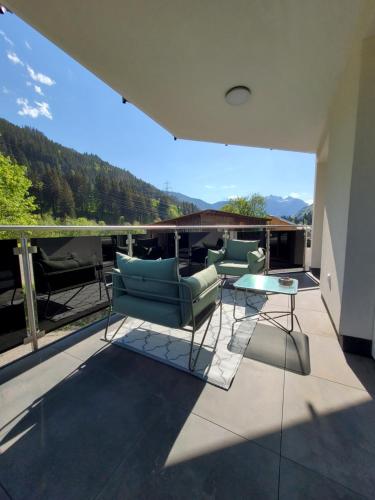 a patio with chairs and a table on a balcony at Arlbergschmiede in Wald am Arlberg