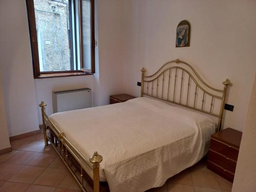 um quarto com uma cama num quarto com uma janela em La casetta de la Rocca em Gualdo Tadino