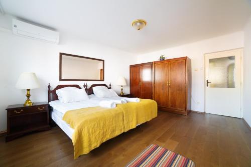 een slaapkamer met een groot bed met een gele deken bij Old Town SCHarajevo - Free Parking in Sarajevo