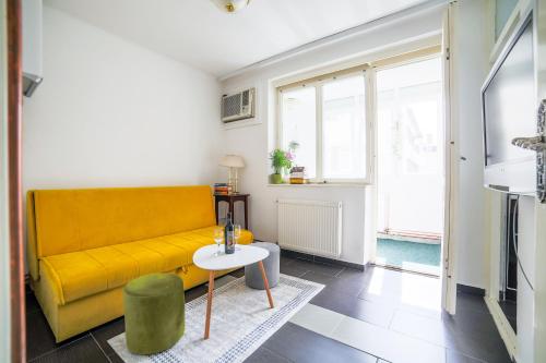 een woonkamer met een gele bank en een tafel bij Old Town SCHarajevo - Free Parking in Sarajevo