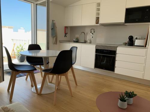 a kitchen with a table and chairs in a room at Peniche36 in Peniche