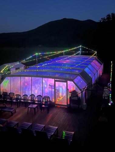 une scène avec des chaises et des lumières allumées la nuit dans l'établissement Villa Les Martinets-Piscine-Jacuzzi-Voie Verte-Gorges d'Héric-Massif du Caroux Mons Olargues 34600, à Le Poujol-sur-Orb