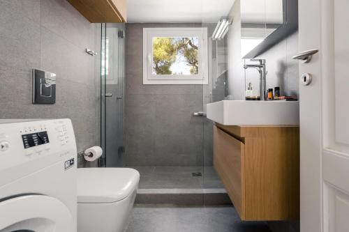 a bathroom with a toilet and a sink and a shower at Hermes&Dione in Argoulidhés