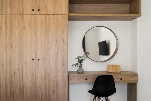 a mirror on a wall next to a desk and a chair at Hermes&Dione in Argoulidhés
