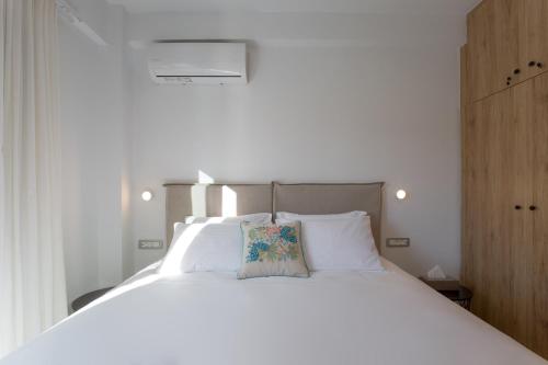 a white bed with a pillow on top of it at Hermes&Dione in Argoulidhés