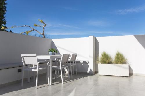 a balcony with a table and chairs on a white wall at Hermes&Dione in Argoulidhés