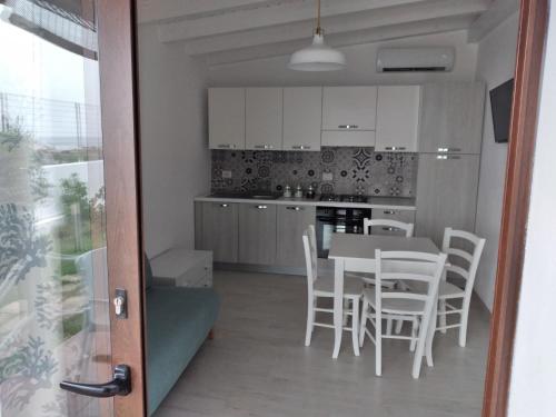 eine Küche und ein Esszimmer mit einem Tisch und Stühlen in der Unterkunft Villetta Terranova 2 in Lampedusa