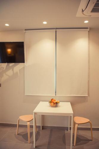 a table with two chairs and a bowl of fruit on it at IO Luxury Pool & Hot Tub Suites in Preveza