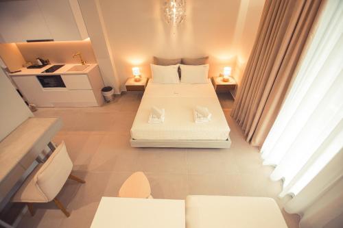 a room with two beds and a kitchen in it at IO Luxury Pool & Hot Tub Suites in Preveza
