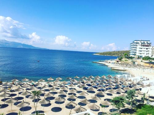 un grupo de sombrillas en una playa junto al océano en Rock Apartments, en Sarandë