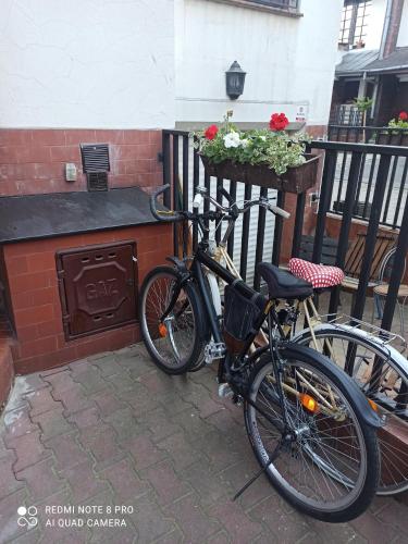 a bike parked next to a building with flowers at Hotel-hostel Saska in Warsaw
