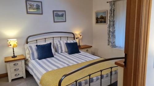 a bedroom with a bed with blue pillows and a window at Mountain View in Ulverston