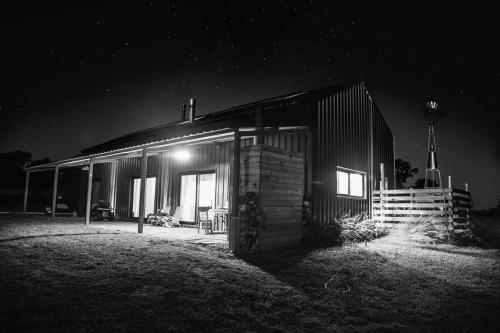 a house with a light on the side of it at night at Casa de Campo Galpon San Antonio de Areco in San Antonio de Areco