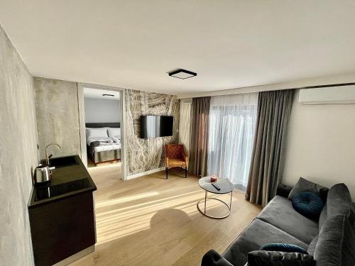 ein Wohnzimmer mit Sofa und ein Schlafzimmer in der Unterkunft Plaza Apartments in Sarajevo