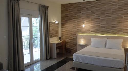 - une chambre avec un lit et un mur en briques dans l'établissement Elata-Apartments, à Thasos