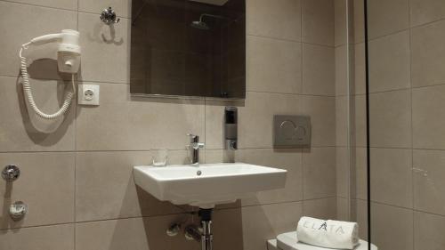 a bathroom with a sink and a toilet and a phone at Elata Apartments in Limenas