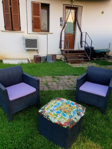 two chairs and a ottoman sitting in the grass at Casa Rosa in Elice