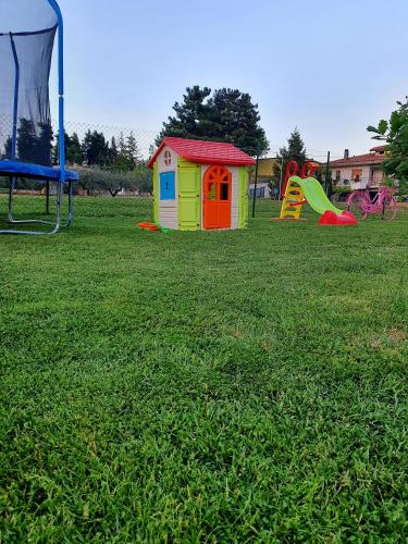 a playground with play equipment in a grass field at Casa Rosa in Elice