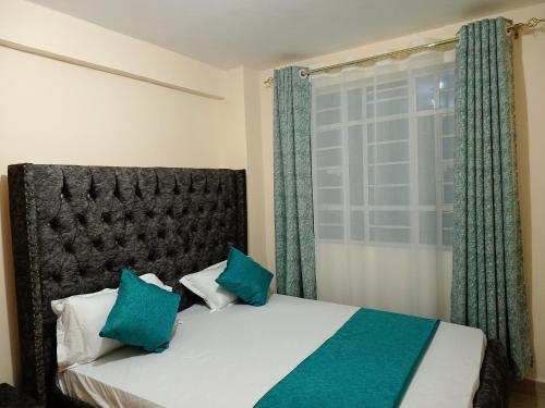 a bedroom with a bed and a window with green curtains at Executive 1-bedroom, in Ruiru in Nairobi