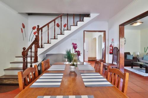 a dining room with a table and a staircase at Casa Quinta das Férias in Ginetes