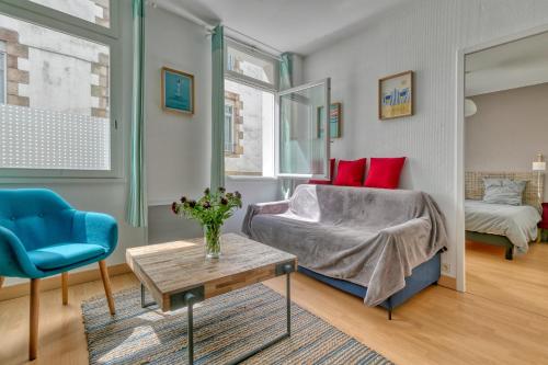 un salon avec un lit et une table dans l'établissement Appartement Le Pouliguen Centre, au Pouliguen