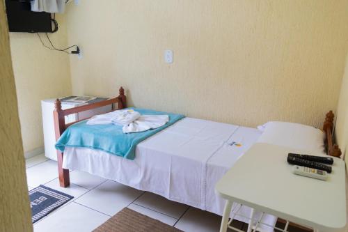 a small bedroom with a bed and a desk and a table at Hotel Naturalis in Paranaguá