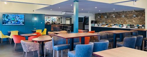 a restaurant with tables and chairs and a bar at Almondsbury Inn & Lounge in Almondsbury