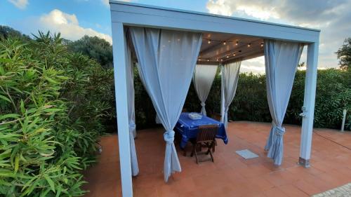 a pergola with a table and chairs on a patio at Villa Kuky in Santa Teresa Gallura