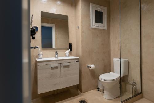 y baño con aseo, lavabo y espejo. en Onar hotel, en Palaia Epidavros