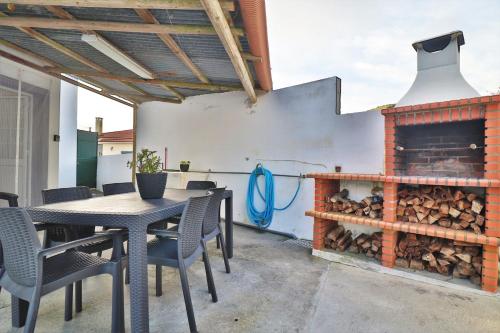 a patio with a table and chairs and a fireplace at Casa Quinta das Férias in Ginetes