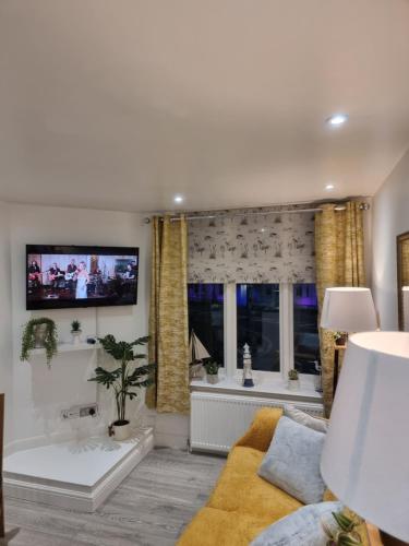 a living room with a tv and a bath tub at 3 Minute Walk to Beach - Couldn't be much closer to sea in Bournemouth