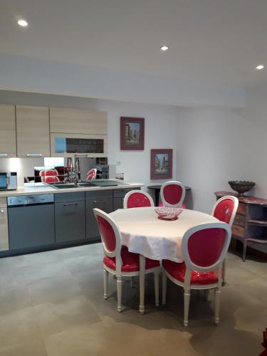 une cuisine avec une table et des chaises rouges dans l'établissement Flor'Ever en Champagne, à Fleury-la-Rivière