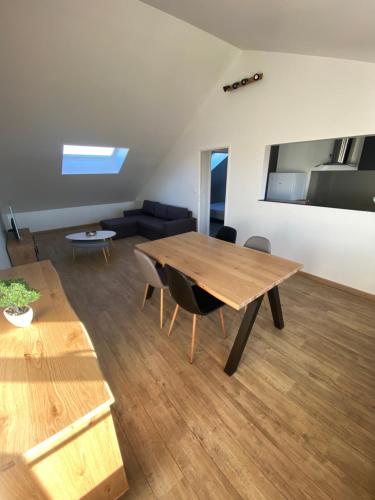 a living room with a wooden table and chairs at Superbe appartement proche CV in Bourges