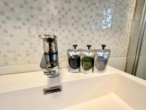 łazienka z umywalką i 3 butelkami mydła w obiekcie COC - Villa Le Grand Terrain - Vue Mer w mieście Wissant