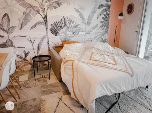 une chambre avec un lit avec un papier peint tropical dans l'établissement Au85, Bel appartement, vue océan, pied de la plage, à Saint-Jean-de-Monts