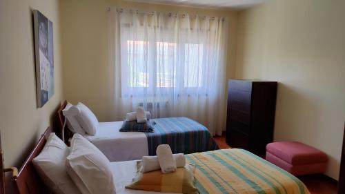 エシュポゼンデにあるT2 em condomínio com piscina - Ofir - Esposendeの小さなベッドルーム(ベッド2台、窓付)