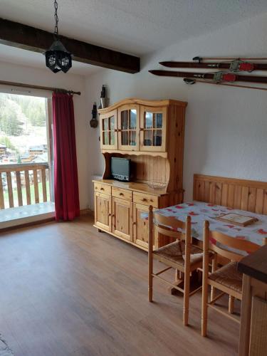 a living room with a table and a cabinet and a television at La Foux d'Allos IDEAL 4 personnes in La Foux