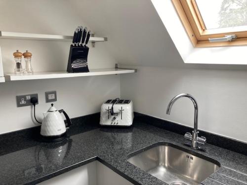encimera de cocina con fregadero y ventana en Letting Serviced Apartments - Chorleywood Village, en Chorleywood