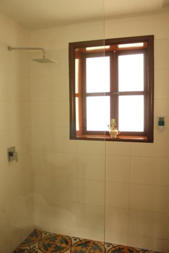 a bathroom with a window and a shower at Casa Muntú - La Candelaria in Bogotá