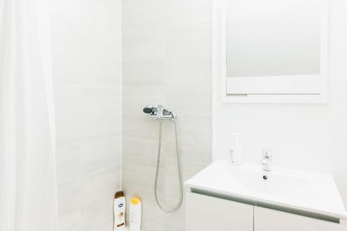 a white bathroom with a shower and a sink at Bird House in Lourinhã