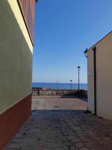 een leeg steegje met de oceaan op de achtergrond bij Sa Calla Manna in Portoscuso