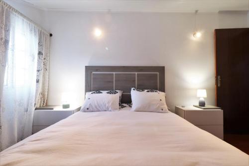 a bedroom with a large white bed with two pillows at Casa Quinta das Férias in Ginetes